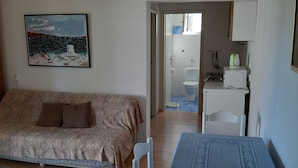 Un dormitorio con cama, una mesita y un cuadro en la pared.
