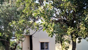 Un petit bâtiment d’un seul étage, doté d’une terrasse en bois et d’un chemin de gravier menant à une porte.