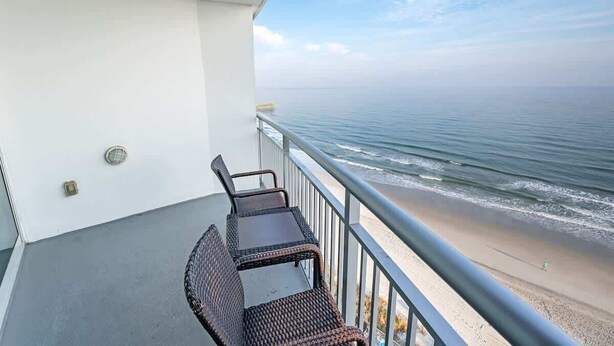 Un balcón con vista al océano y la playa.