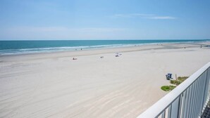 A beach with a clear sky, sandy shore, and a few umbrellas. - New Low Floor Direct Ocean Front at Sands Beach Club (Myrtle Beach)