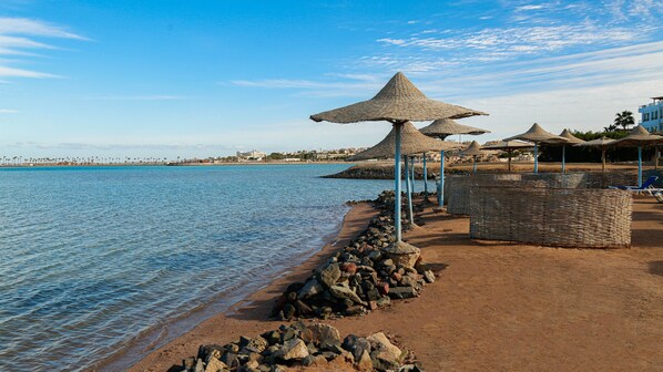 Praia particular, espreguiçadeiras, guarda-sóis, toalhas de praia