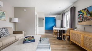 Ein modernes Wohnzimmer mit Sofa, Couchtisch und Essbereich mit Stühlen und Tisch.