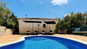 A swimming pool with lounge chairs and umbrellas, surrounded by a stone wall and trees. - Teules CostaBravaSi. Swimming pool, parking, wifi (Santa Cristina d'Aro)