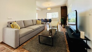 A modern living room with a grey sofa, a coffee table, and a TV on a black stand. - Teules CostaBravaSi. Swimming pool, parking, wifi (Santa Cristina d'Aro)