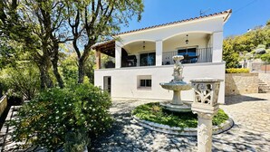 A white building with a tiled roof, a stone fountain, and lush greenery. - Teules CostaBravaSi. Swimming pool, parking, wifi (Santa Cristina d'Aro)