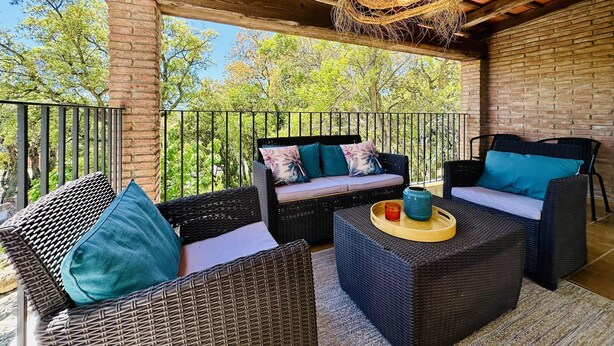 An outdoor patio with wicker furniture, a hanging light fixture, and a view of trees. - Teules CostaBravaSi. Swimming pool, parking, wifi (Santa Cristina d'Aro)