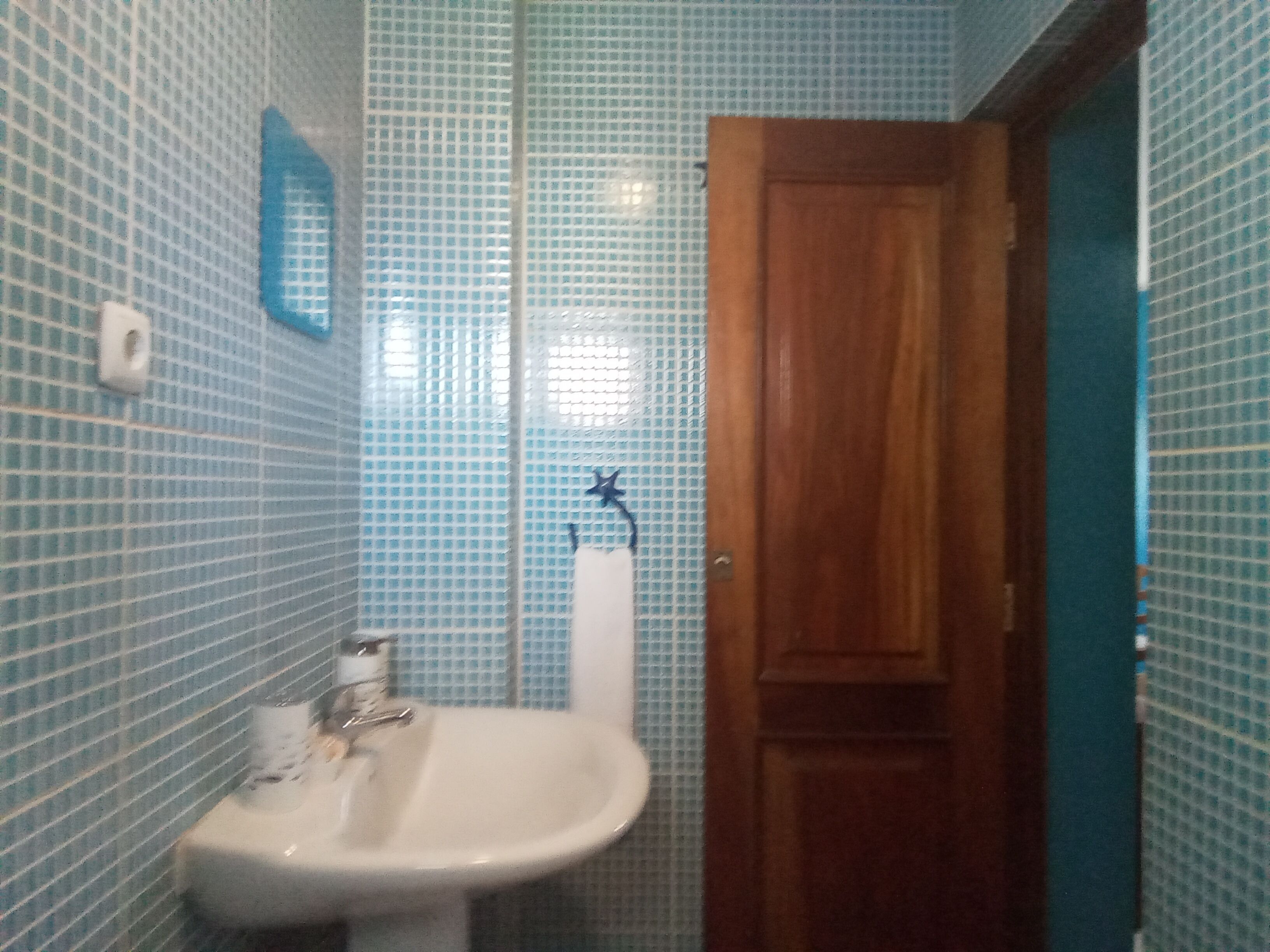 Un baño con lavamanos, espejo e inodoro.