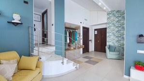 A modern interior with a staircase, a sofa, a coat rack, and a patterned wall. - Casa Cristina Green (Sorrento)