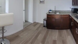A modern kitchen with wooden cabinets, a stainless steel sink, and a countertop. - Amazing Melly's (Tampa)