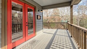 A wooden deck with a red door and a welcome mat. - Beary’s Den where Chic meets Country in this Cozy Cabin (Murphy)
