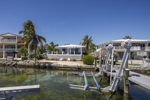 Un port de plaisance avec une eau claire, un quai et un bâtiment doté d’une zone abritée.
