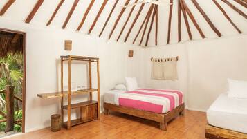 A room with a wooden bed, a wooden nightstand, a wicker chair, and a ceiling fan.