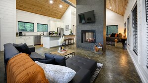 Een modern interieur met een zithoek, keuken en open haard.