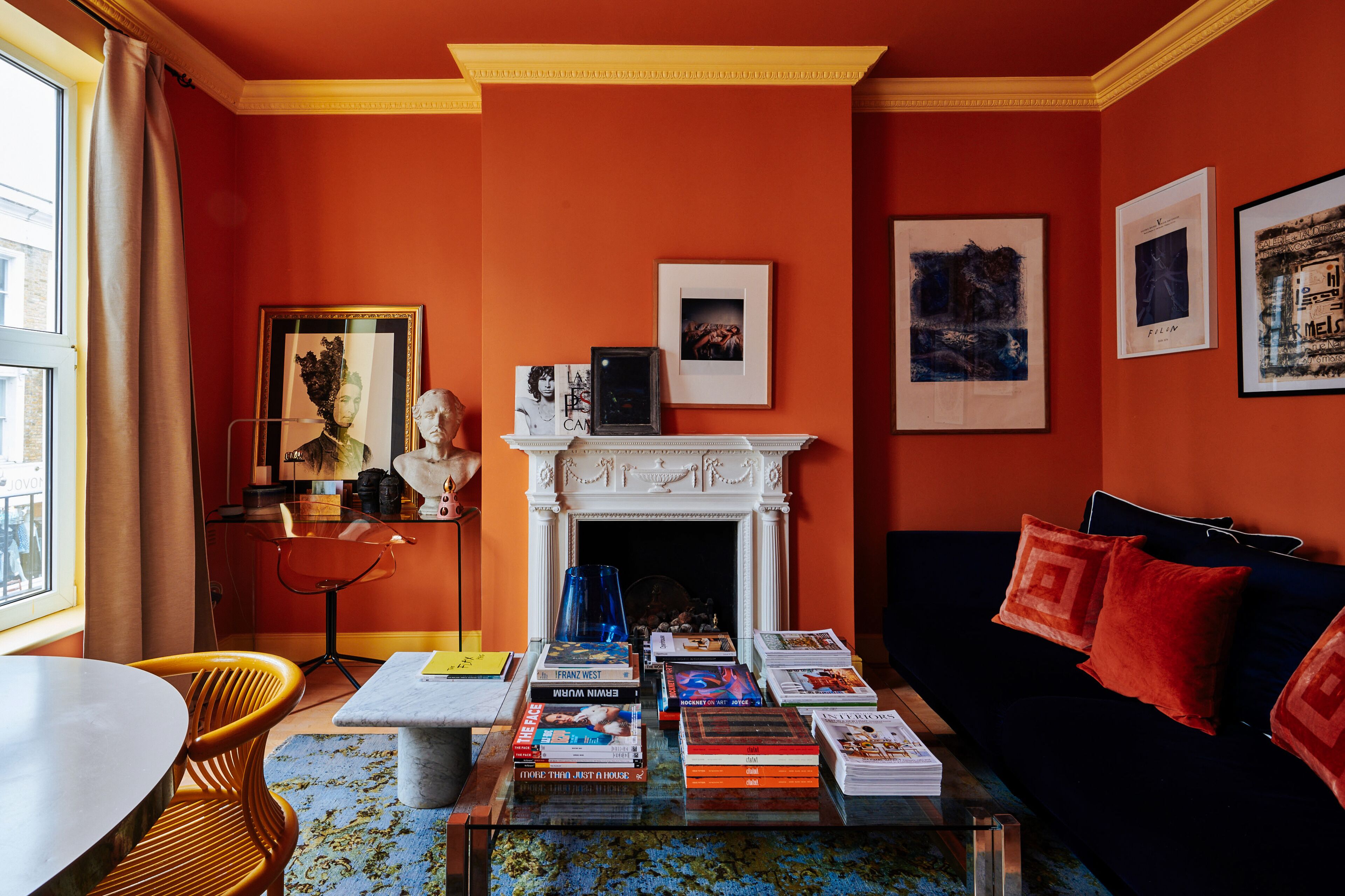 Ein Zimmer mit Kamin, Büchern, einer Couch und einem Essbereich.