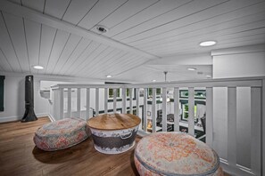 A spacious balcony with a white railing, a large fan, and three round ottomans with floral patterns. - Pool l Hot Tub, Sunrise & Mountain VIEWS (Mentone)