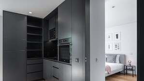 Une chambre à coucher moderne avec un lit, une table de chevet et une petite commode.