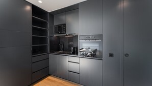 Une cuisine compacte dotée d’appareils électroménagers intégrés, d’un four à micro-ondes et d’une cuisinière.