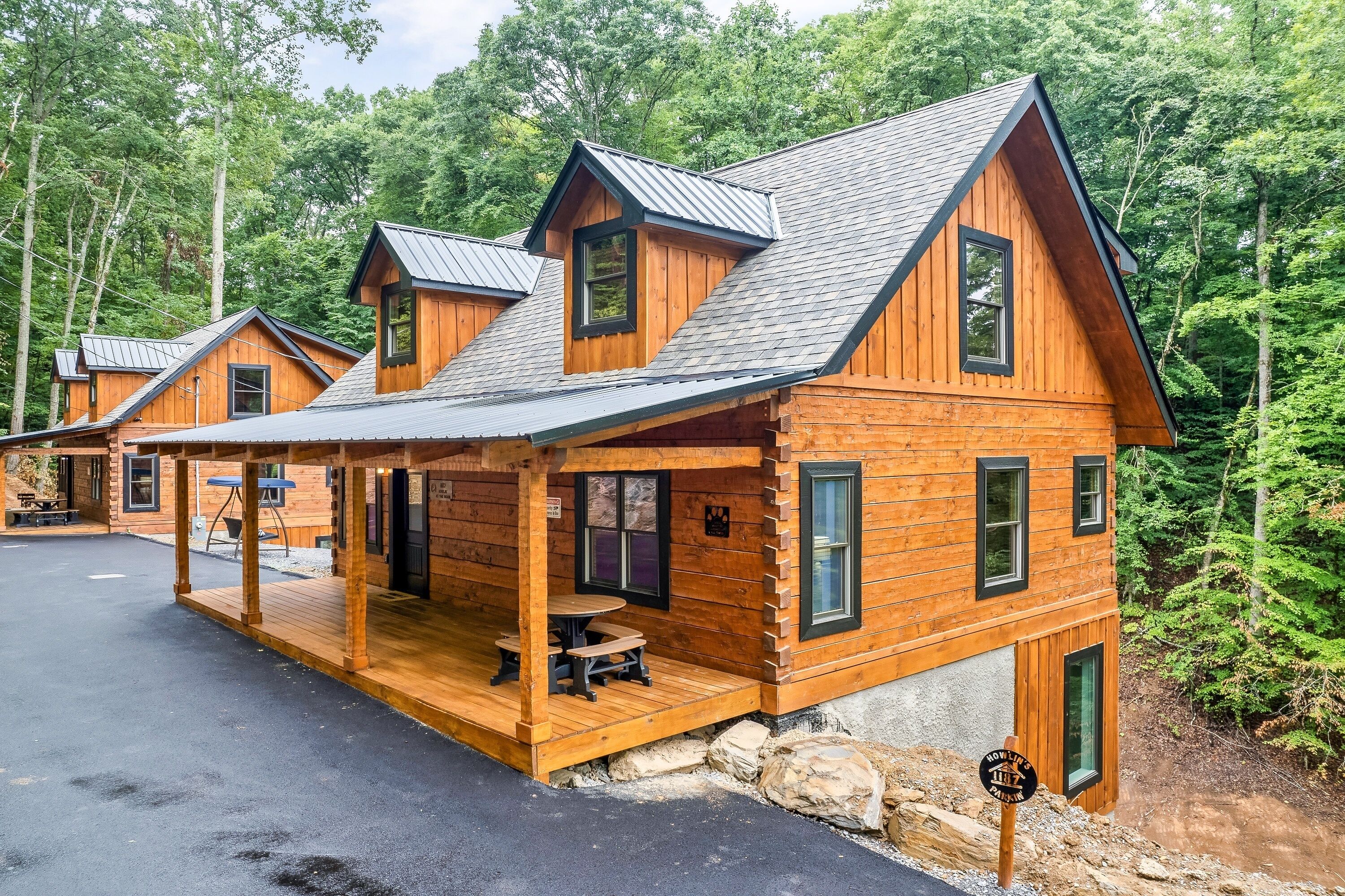 Une rangée de cabanes en bois avec des toits à deux versants, une véranda couverte et une table de pique-nique.