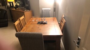 A wooden dining table with chairs, a small cabinet, and a lamp. - Captivating Apartment Near Gatwick (Crawley)