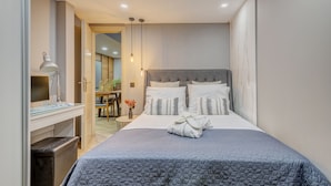 A modern bedroom with a large bed, a desk, and a chair. - 2-bed Pool Villa in Panormo (Mylopotamos)