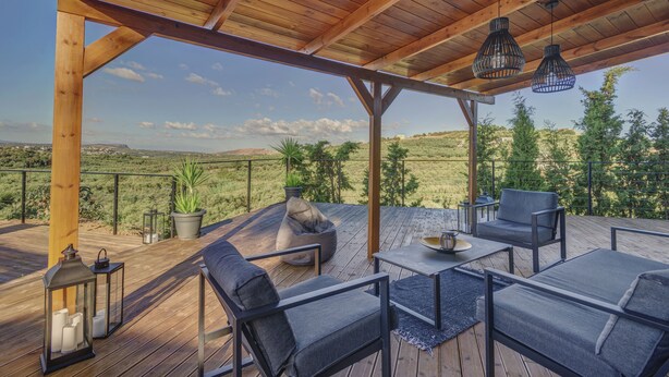 An outdoor deck with wooden flooring, seating arrangements, and hanging lanterns. - 2-bed Pool Villa in Panormo (Mylopotamos)