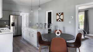 Una cocina moderna con una isla central, electrodomésticos de acero inoxidable e iluminación colgante.