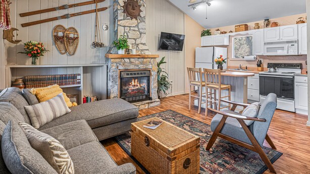 A cozy living room with a fireplace, a dining area, and a kitchen. - Still Standing! Cozy Cottage, Incredible Location! (Lake Lure)