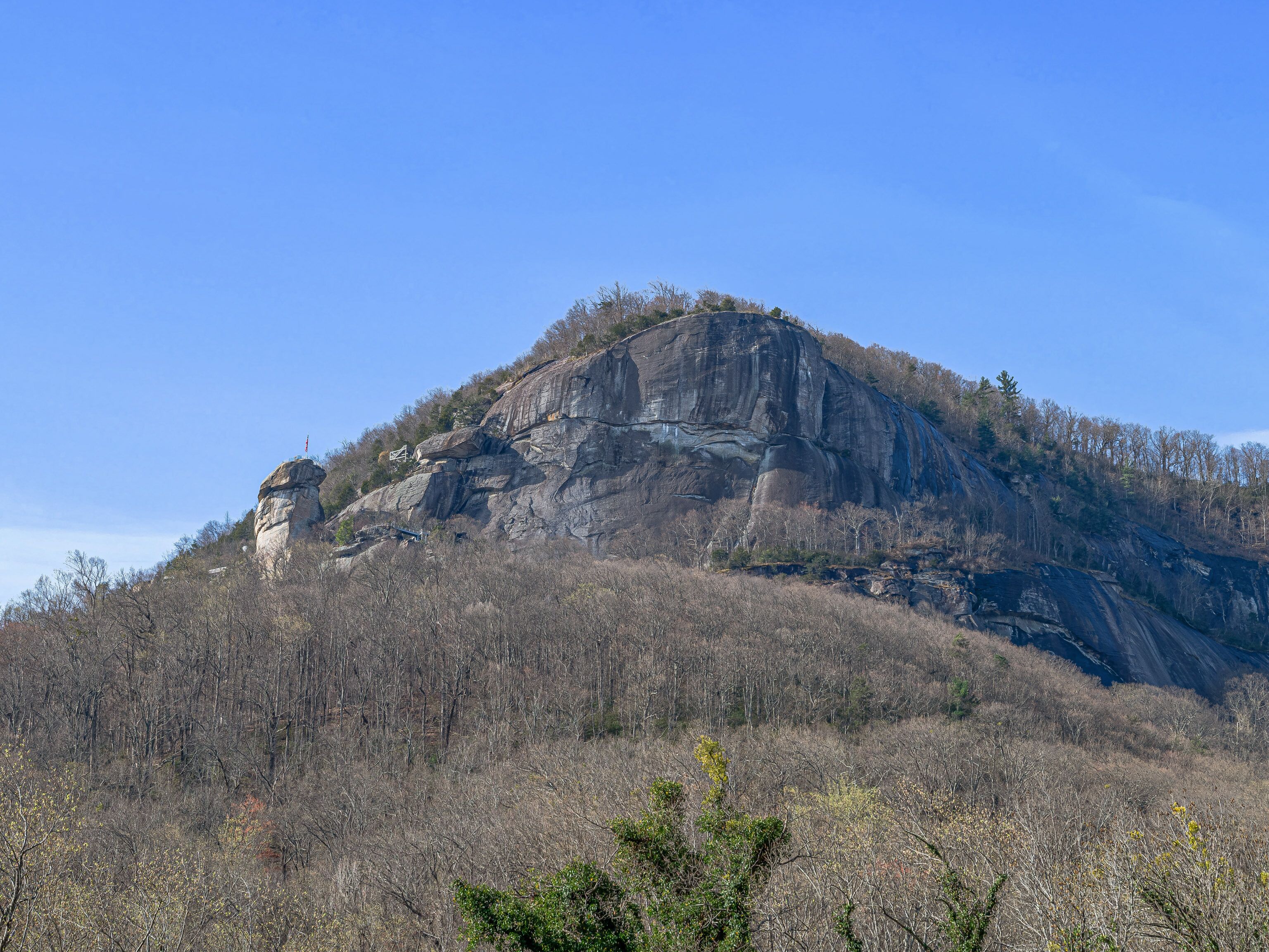 Eine große Felsformation mit einer kleinen Hütte darauf.