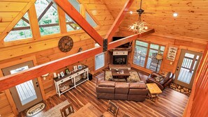 A spacious cabin with a high ceiling, wooden walls, and large windows. - Gorgeous custom log cabin on 185 acres (Dellrose)