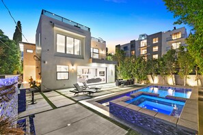 Un immeuble résidentiel moderne doté d’une piscine, d’un espace extérieur aménagé et d’un jardin bien entretenu.