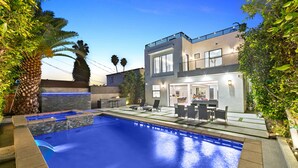 A modern two-story house with a swimming pool, outdoor seating, and a balcony. - Beverly Hills Playhouse with Rooftop & Pool (Los Angeles)