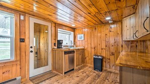 Cocina con paneles de madera, lavavajillas, pileta y ventana.