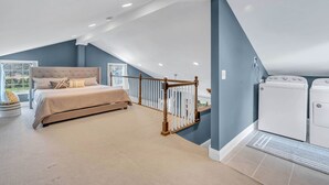 Ein Schlafzimmer mit einem großen Bett, einem Hollgeländer und einer Waschmaschine.