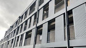 A multi-story building with a modern architectural design, featuring a series of balconies and large windows. - Luxury 2-bed Apartment in Manchester With Parking (Salford)