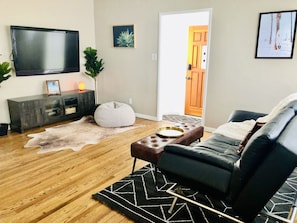 Relax in this stylish living room with a flat-screen TV, comfortable sofa, and plush bean bag chair.