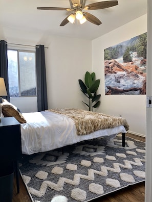 Relax in this serene bedroom with a large bed, ceiling fan, and scenic river view.