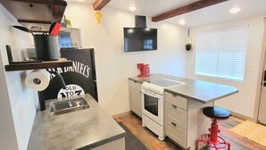 A compact kitchen with a built-in oven, a small countertop, and a red stool. - Comfortable, Laid-back Cottage. Private Yard. Near Zion. 2 Bedroom, Full Kitchen (Hurricane)