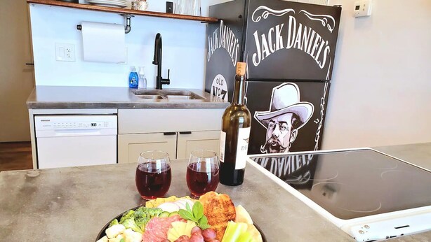 A kitchen with a dining table set with a charcuterie board, wine glasses, and a bottle of wine. - Comfortable, Laid-back Cottage. Private Yard. Near Zion. 2 Bedroom, Full Kitchen (Hurricane)