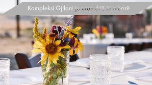 A table set for dining with a centerpiece of a jar containing flowers. - La Luna Resort Ksamil (Ksamil)
