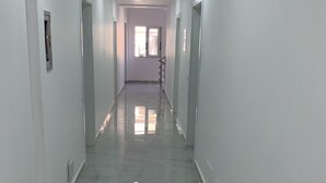 A long, narrow hallway with white walls and a shiny, reflective floor. - La Luna Resort Ksamil (Ksamil)