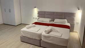 A modern bedroom with a bed, a wardrobe, and a red accent on the bed. - La Luna Resort Ksamil (Ksamil)