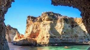 A coastal view through a cave entrance with clear water and rocky cliffs. - Studio Sleeps 2 with Free Parking (Mexilhoeira Grande)