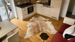 Une cuisine moderne avec des meubles en bois, un plan de travail noir et un pare-feu en pierre.