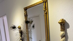 Une commode en bois avec un miroir, des vases et une carafe en cristal.