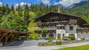 Il s’agit d’un bâtiment de style chalet traditionnel, doté d’un toit en pente, de balcons en bois et d’une entrée avec une porte jaune.