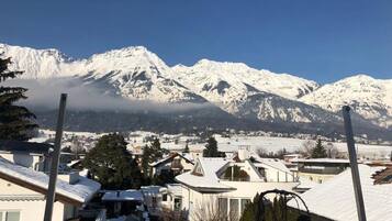 Zona residencial con casas cubiertas de nieve y una cadena montañosa al fondo.
