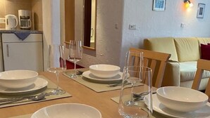 A dining area with a table set for four, including plates, glasses, and cutlery. - Apartment W2 Haus Ganghofer with Mountain View, Shared Terrace & Wi-Fi (Leutasch)