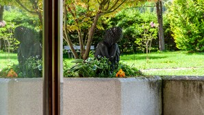 A garden with a statue, a bench, and a concrete wall. - Apartment W3 Haus Ganghofer with Mountian View, Shared Terrace & Wi-Fi (Leutasch)