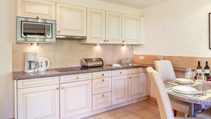 A kitchen with white cabinets, a built-in microwave, a coffee maker, and a toaster. - Apartment W4 Haus Ganghofer with Mountain View, Balcony & Wi-Fi (Leutasch)