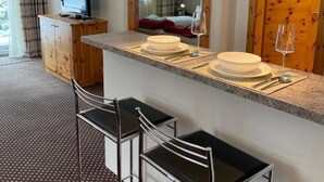 Une cuisine moderne dotée d’un coin bar, d’un téléviseur et d’un espace repas.